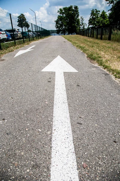 Road marking on asphalt. Painted signs on the roadway for drivers of various vehicles. Dotted line and arrows. Belarus