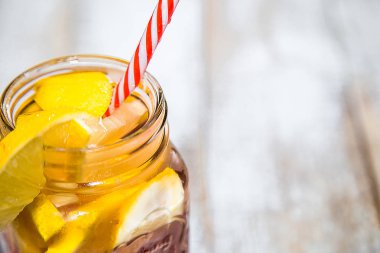 Bir kalem ve saman ile cam kupa limon dilimleri ve buz ile Kokteyl. İngiliz soğuk içecekler klasik bir yazıt ile beyaz bir raf üzerinde duruyor