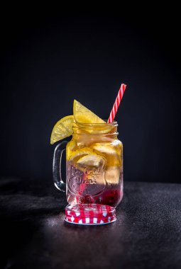 Bir kalem ve saman ile cam kupa limon dilimleri ve buz ile Kokteyl. İngiliz soğuk içecekler klasik bir yazıt ile beyaz bir raf üzerinde duruyor