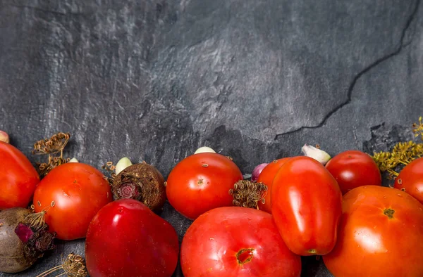 Tomates vermelhos de uma cama de jardim em um backgroun preto — Fotografia de Stock