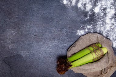 üstleri ile genç tatlı mısır, karanlık bir masa, arka plan üzerinde yatıyor.