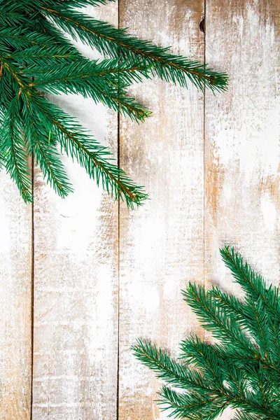 Na bílém dřevěném pozadí leží větvičky z vánočního smrku, c — Stock fotografie
