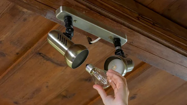 young man screws a light bulb