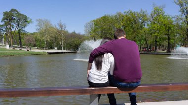 Debrecen Macaristan 04 19 2019 genç çift bir bankta oturan ve Büyük Orman parkı Debrecen bir çeşme bakıyor