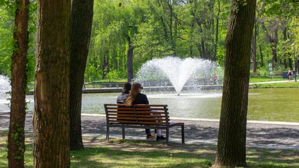 Debrecen Hungría 04 19 2019 pareja joven sentada en un banco y disfrutando del buen tiempo en Debrecen en el parque Great Forest — Foto de Stock