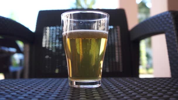 Vaso con cerveza en el fondo de la silla — Vídeo de stock