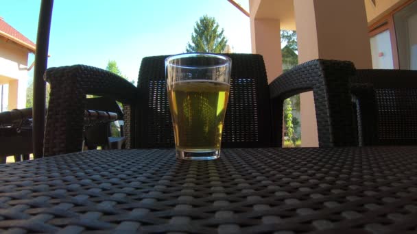 Склянка з пивом на фоні стільця — стокове відео