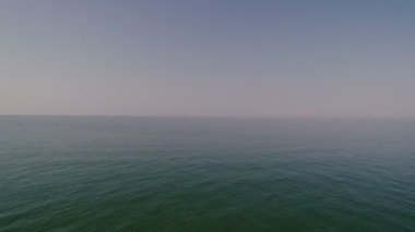 Bir sonsuz sakin açık mavi deniz bulutsuz bir gökyüzünde kefen.