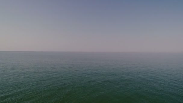 Une mer bleue infiniment calme et limpide entourée d'un ciel sans nuages .