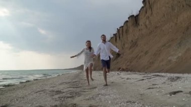 Genç, sevgi dolu çift sahil boyunca sahilde çalışır.