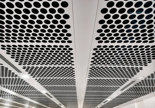 white perforated ceiling with black holes