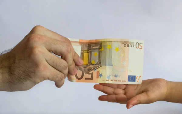 Un hombre ofreciendo dinero a un niño. Dinero en manos — Foto de Stock