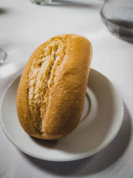 Rollo de pan en una placa redonda blanca —  Fotos de Stock