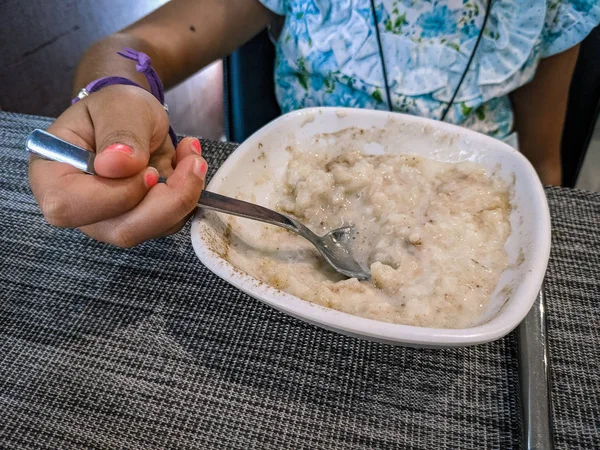 girl eating rice pudding with pink fingernails
