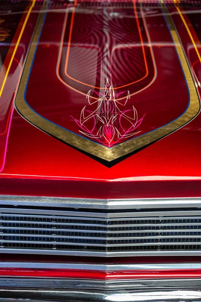 Detal okapu czerwonego i chromowanego samochodu z ręcznie malowanymi liniami — Zdjęcie stockowe