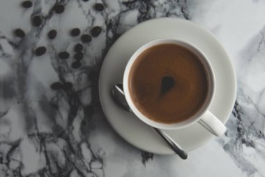 Kahve çekirdekleri ile taze yapılmış kahve lezzetli ve lezzetli bir fincan yukarıdan görünümü