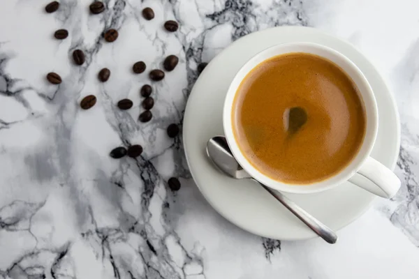 Blick von oben auf eine köstliche und leckere Tasse frisch gemachten Kaffee mit Kaffeebohnen — Stockfoto