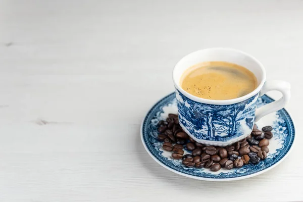 커피 콩을 곁들인 갓 만든 커피의 맛있고 맛있는 오래되고 소박한 컵의 정면 전망 — 스톡 사진