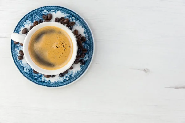 Blick von oben auf eine köstliche und leckere alte und rustikale Tasse frisch gemachten Kaffee mit Kaffeebohnen — Stockfoto