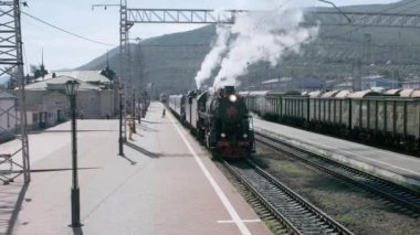 Slyudyanka, Irkutsk region, Rusya Federasyonu - 18 Ağustos 2018: eski Turizm lokomotif maliyeti tren istasyonunda. Bir borudan sigaran yoktur ve Tekerlekli çiftler altından. Çevre-baykal demiryolu eski tren turu.
