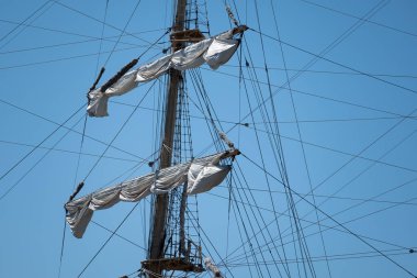 Mavi gökyüzüne karşı gemi yelken ahşap direkler.