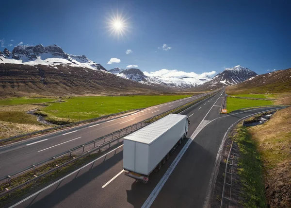 高速公路上装有集装箱的速递半卡车驶过山脉 驶向太阳 运输概念 — 图库照片