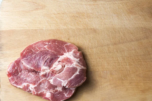 bir kesme tahtası üzerinde iki domuz eti biftek