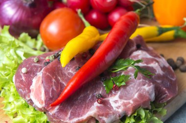 Domuz eti boyun eti biftek marul, turp, domates, kırmızı biber, sarı biber, yeşil kırmızı biber, sarı biber, kırmızı biber, kara biber ve arka plan üzerinde üzerinde. Yatay. Kırmızı soğan, arpacık. Mermer et