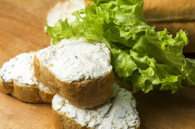 Mini baget sandviç kesme tahtası üzerinde krem peynirli