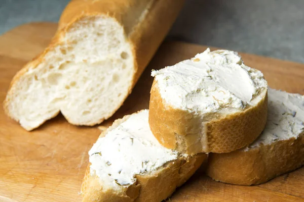 Mini baget sandviç kesme tahtası üzerinde krem peynirli