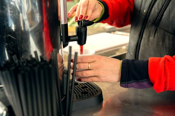 Kız fuarda bir termos mulled şarap dökülen