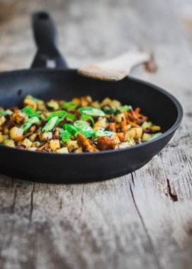 siyah bir tavada Rosted chanterelles ve patates soğan ile servis