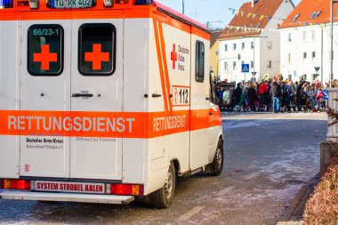 Rottenburg Am Neckar, Almanya - 26 Şubat 2017: Geleneksel karnaval geçit sonra arka planda kostümlü insanlar ile Alman ambulans araba