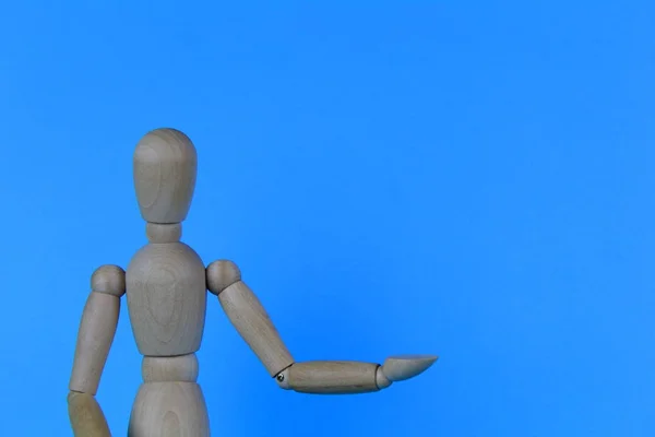 Figura Homem Madeira Com Uma Mão Estendida Sobre Fundo Azul — Fotografia de Stock