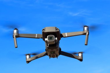 Güneşli bir günde mavi gökyüzüne karşı drone uçuş. Önden görüntüle.
