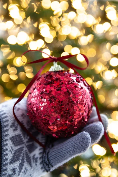 Hand Houden Van Een Feestelijke Kerstbal Voor Bokeh Lichten — Stockfoto