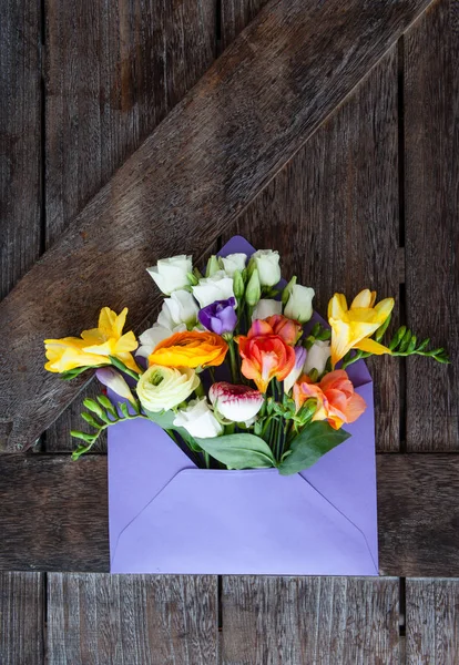 Paarse Envelop Met Verse Lentebloemen Houten Achtergrond — Stockfoto