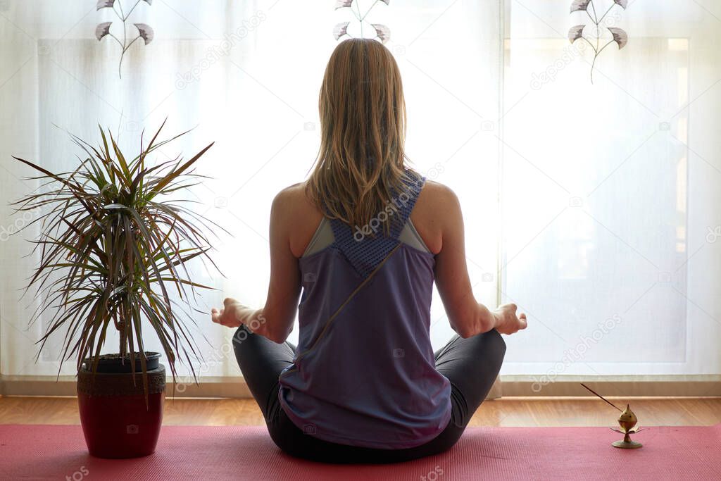 Woman doing meditation at home, meditation posture.