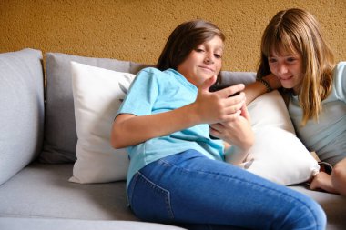 Akıllı telefon kullanan iki arkadaş.