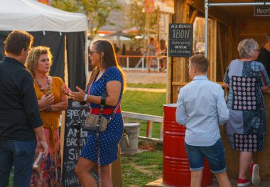 İki kadın ve bir adam içki tezgâhında konuşup içiyorlar. Bir erkek ve yaşlı bir kadın içecek bir şeyler almak için sırada duruyorlar..