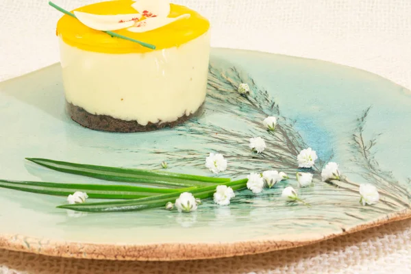 Yellow cake on the blue plate with flora pattern