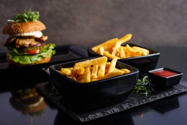 Patates kızartması siyah arka plan üzerine plaka.