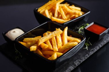 Patates kızartması siyah arka plan üzerine plaka.