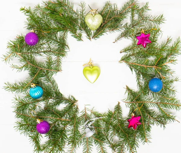 Yeni yılın renkli süslemeleri ve beyaz ahşap masada noel ağacı dalları. Arkaplan resmi. 