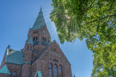 Sofya Kilisesi (Sofia kyrka), İsveç 'in Stockholm kentindeki büyük kiliselerden biri olan İsveç Kraliçesi Sophia' nın adını aldı. Güneş ışınları ve ağaçla görüntüle.
