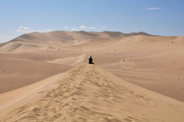 Dunhuang, Gansu, Çin için bir çöl kabuklarıyla yalnız oturan adam