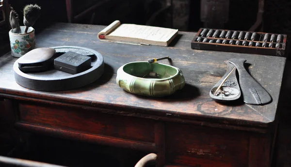 Writing wooden desk with writing instruments, abacus, paper notes and brushes in Pingyao, Shanxi, China