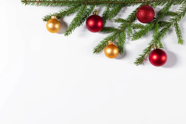 Christmas border of fir branches, gold and red balls on a white background. Flat lay, top view, copy space. Christmas background