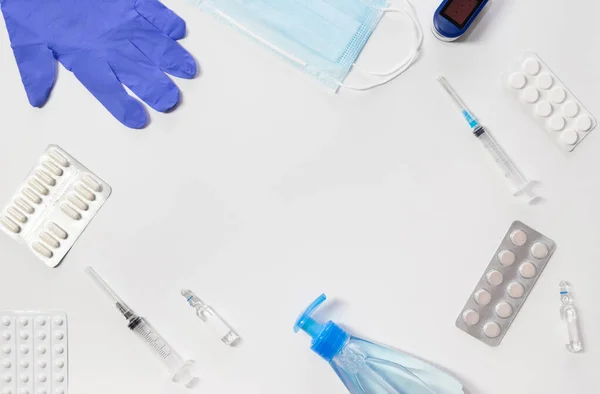 Medical kit. Gloves, syringe, mask, tablets and sanitizer, pulse oximeter on a white background. Means for the prevention and treatment of coronavirus. Covid-19, healthcare concept. Copy space.