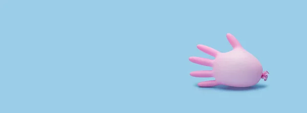 Pink medical inflated glove on a blue background. Banner. Prevention of coronavirus, covid-19. Healthcare concept. Copy space.